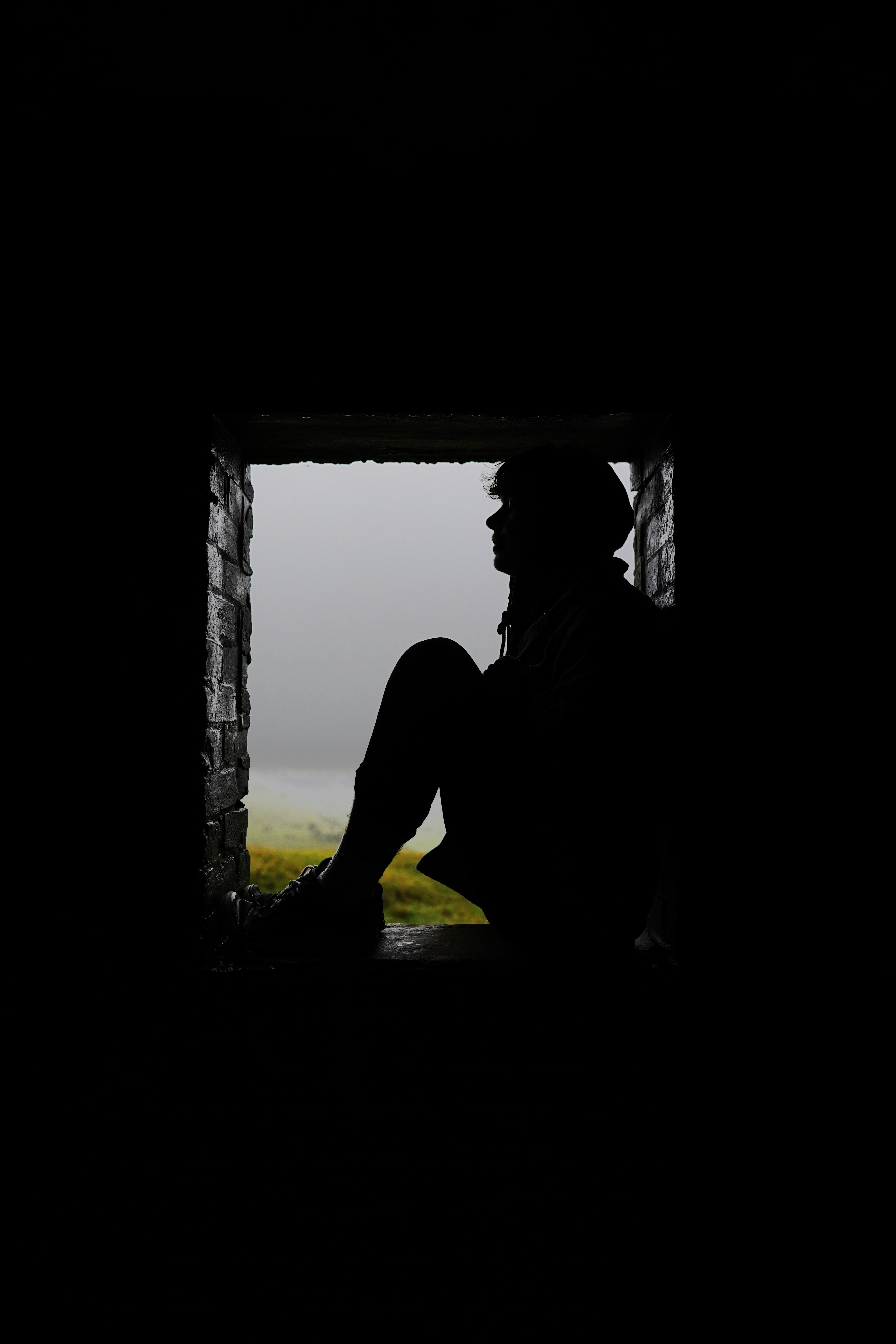 silhouette of man standing near window during daytime